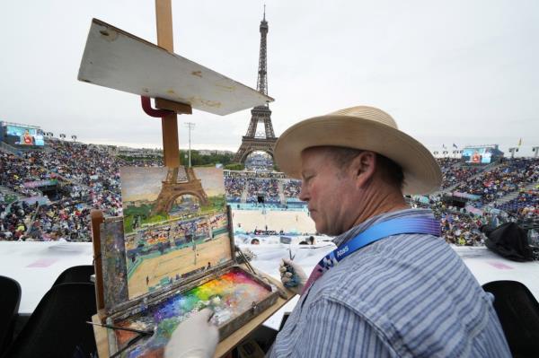 Peter Spens, of London, England, paints the scene at Eiffel Tower Stadium during a beach volleyball match at the 2024 Summer Olympics, Saturday, July 27, 2024, in Paris, France. — AP Photo/Robert F. Bukaty